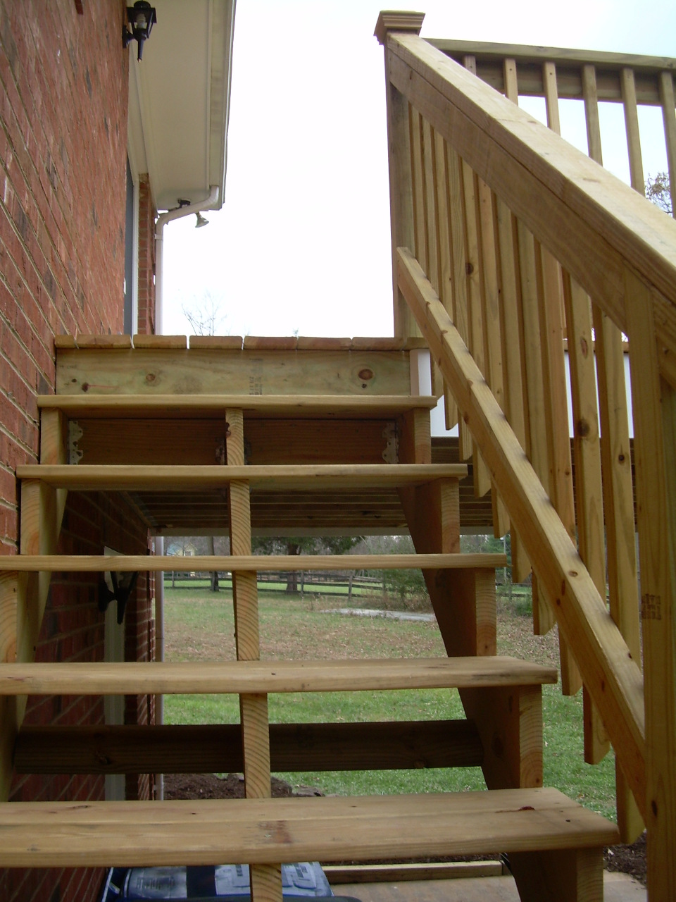 Traditional framed deck steps in Charlottesville VA featuring a six-tread staircase transitioning down a backyard hill.