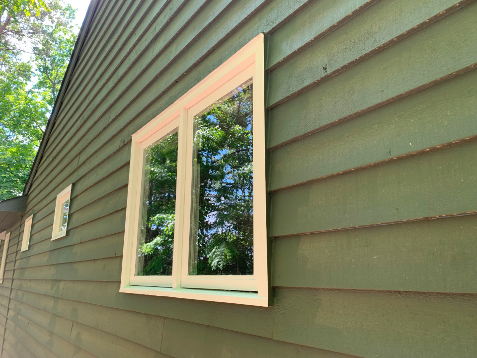 Final result: the rebuilt sash, brickmold, and frame fully finished with paint, restoring a clean and uniform exterior appearance.