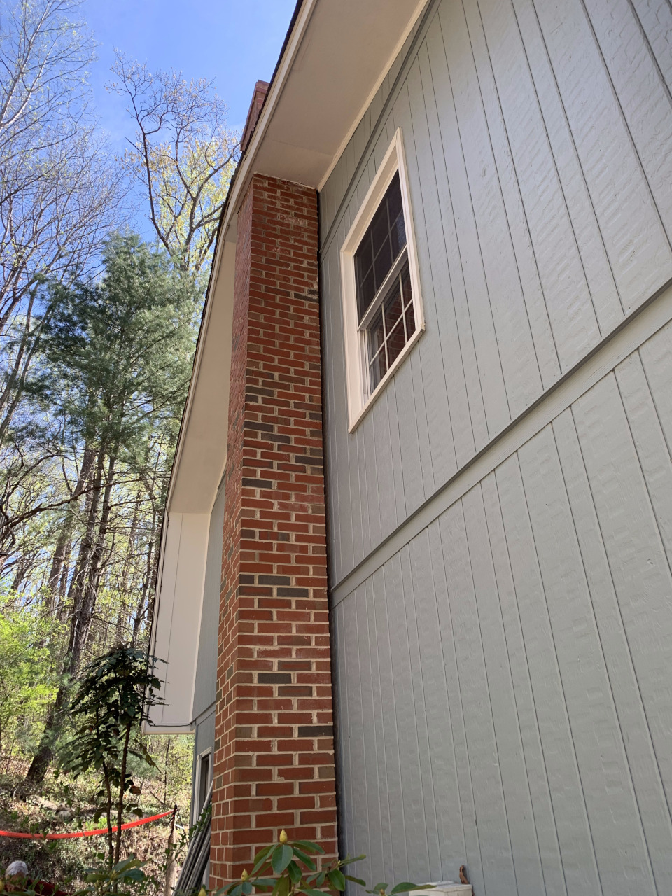 The chimney shows visible separation from the house before work began.