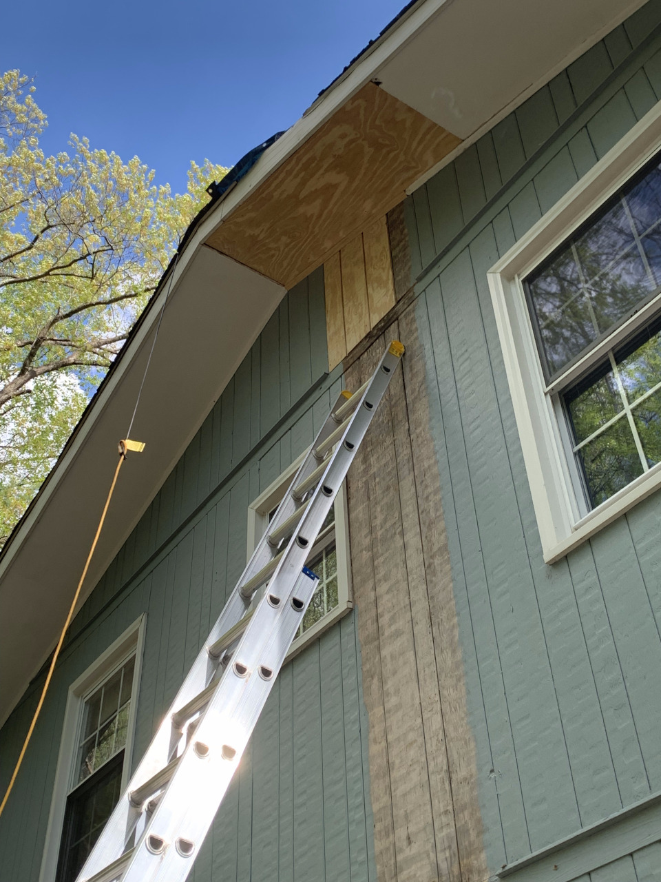 The new soffit plywood is visible along with the newly installed section of T1-11 siding.