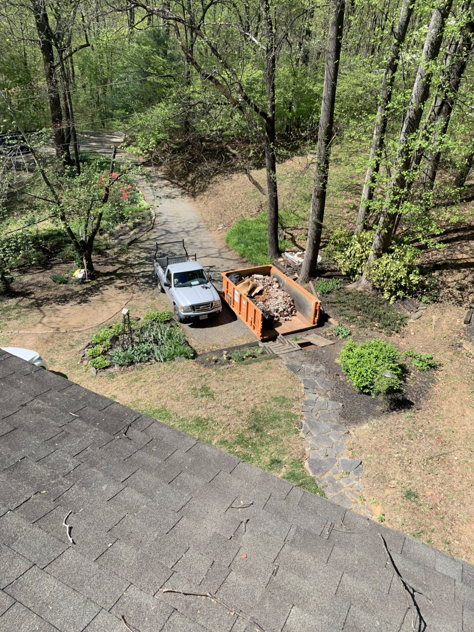 A roof-level view shows a dumpster filled with removed chimney bricks.