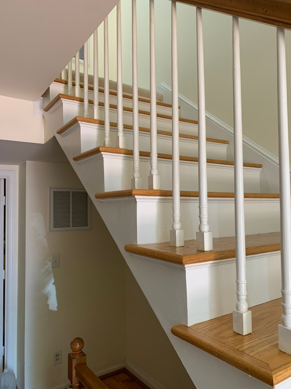 Completed stairway with restored trim and freshly painted walls, view two.