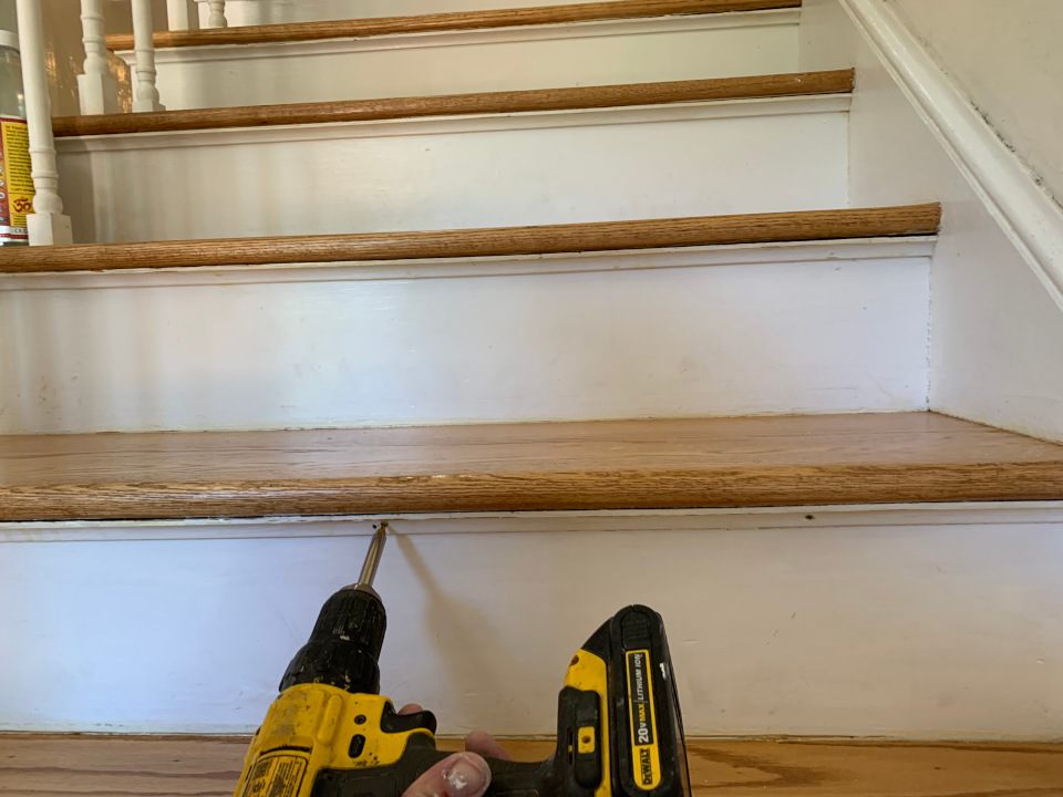 Securing loose trim with a screw to stabilize the profile before surface restoration.