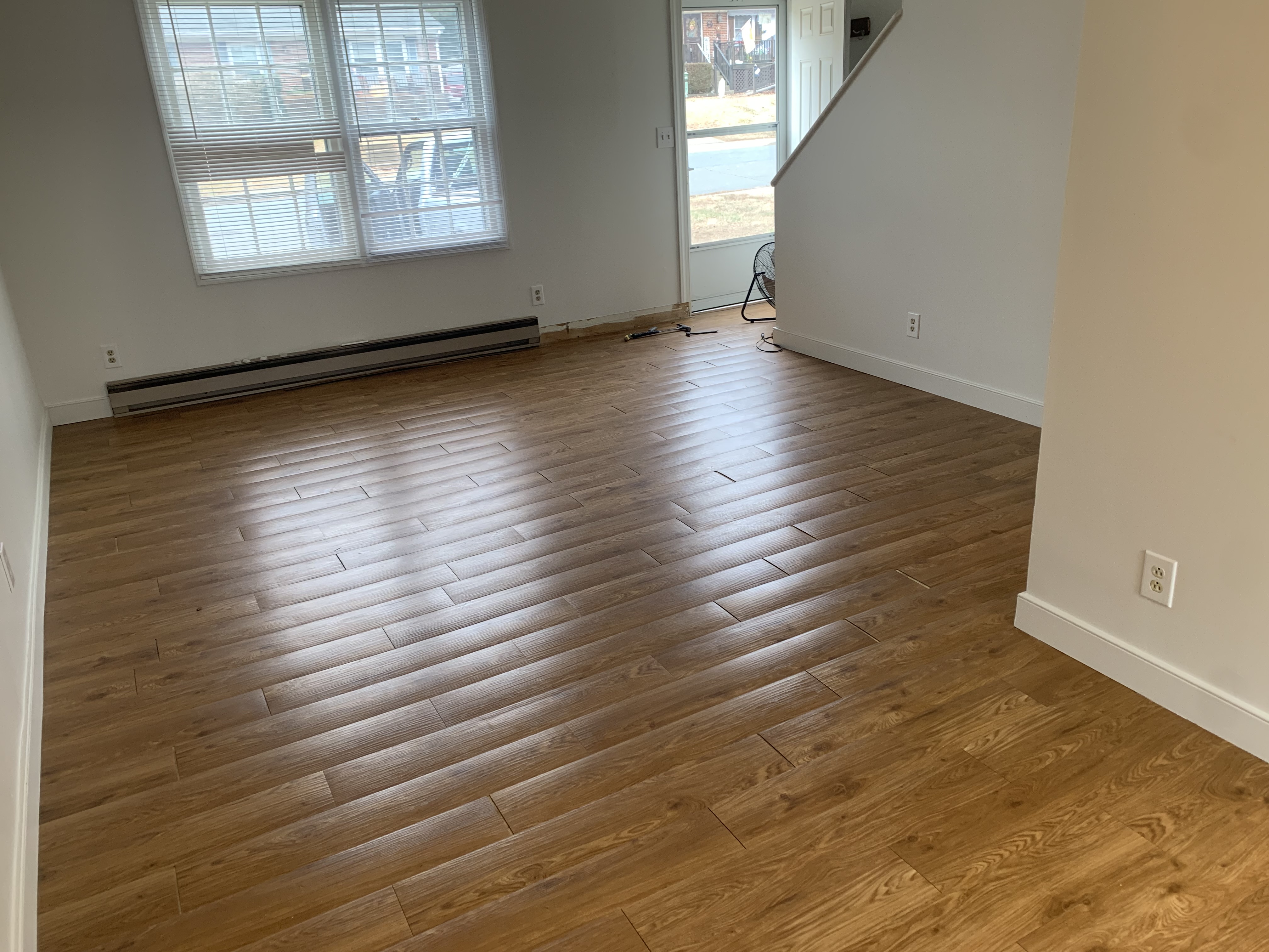 Original flooring with loose planks and failing adhesive