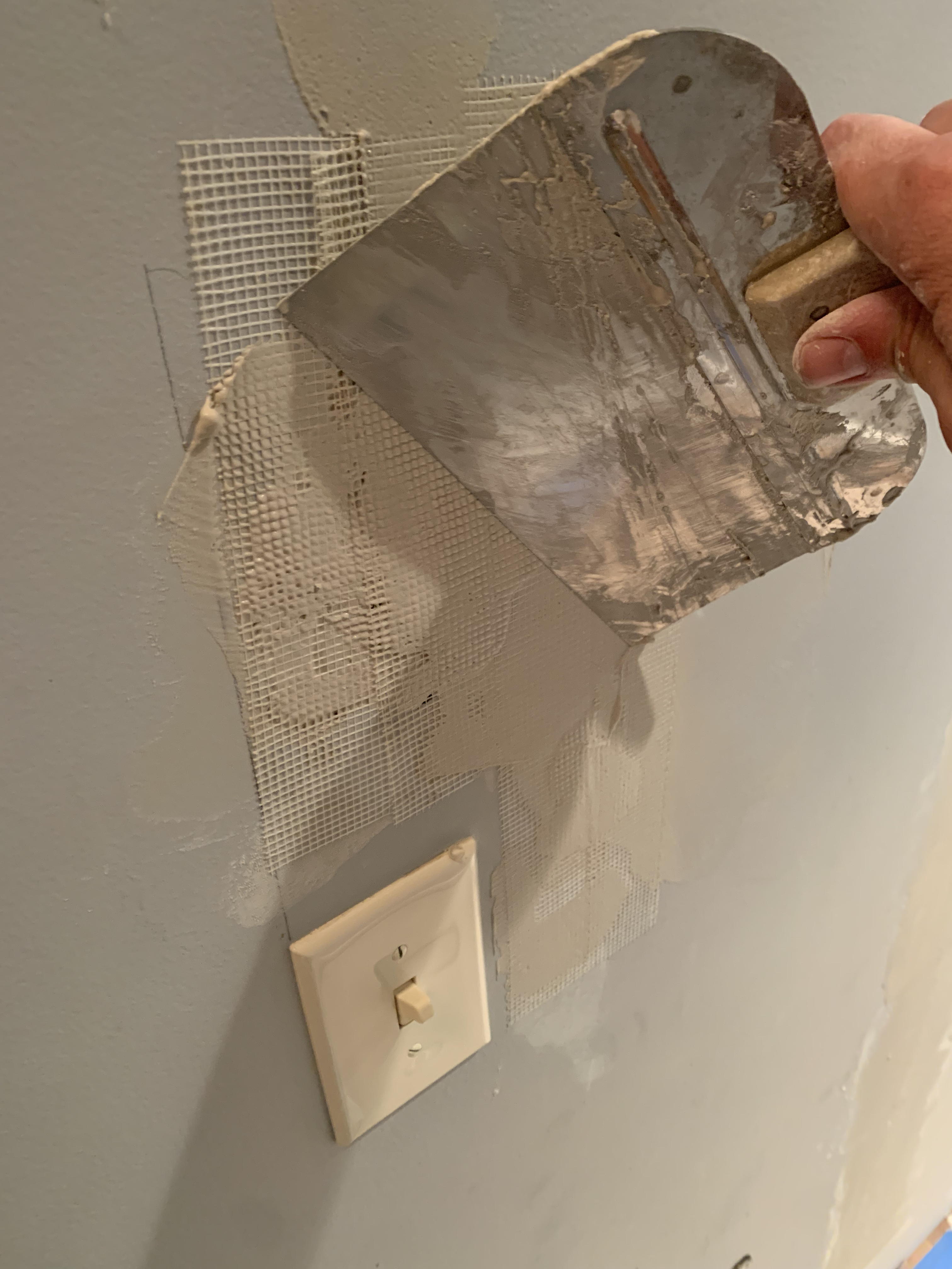 Mesh tape was applied to secure the area and transition the new compound into the existing wall.