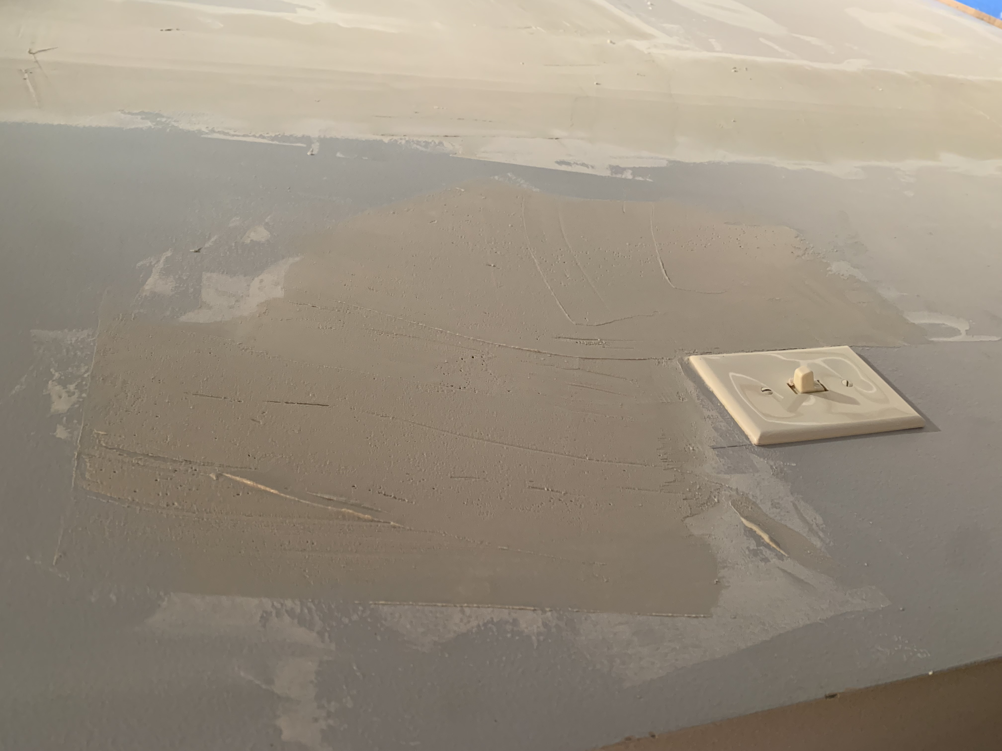 Multiple coats of joint compound were applied and feathered out to level the surface.